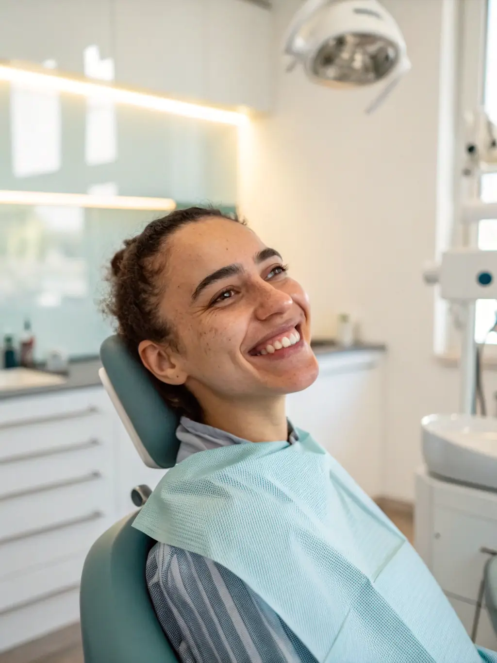 A patient smiling confidently with a full set of teeth after undergoing All-on-4/All-on-6 treatment. The setting is a modern dental clinic in Albania.